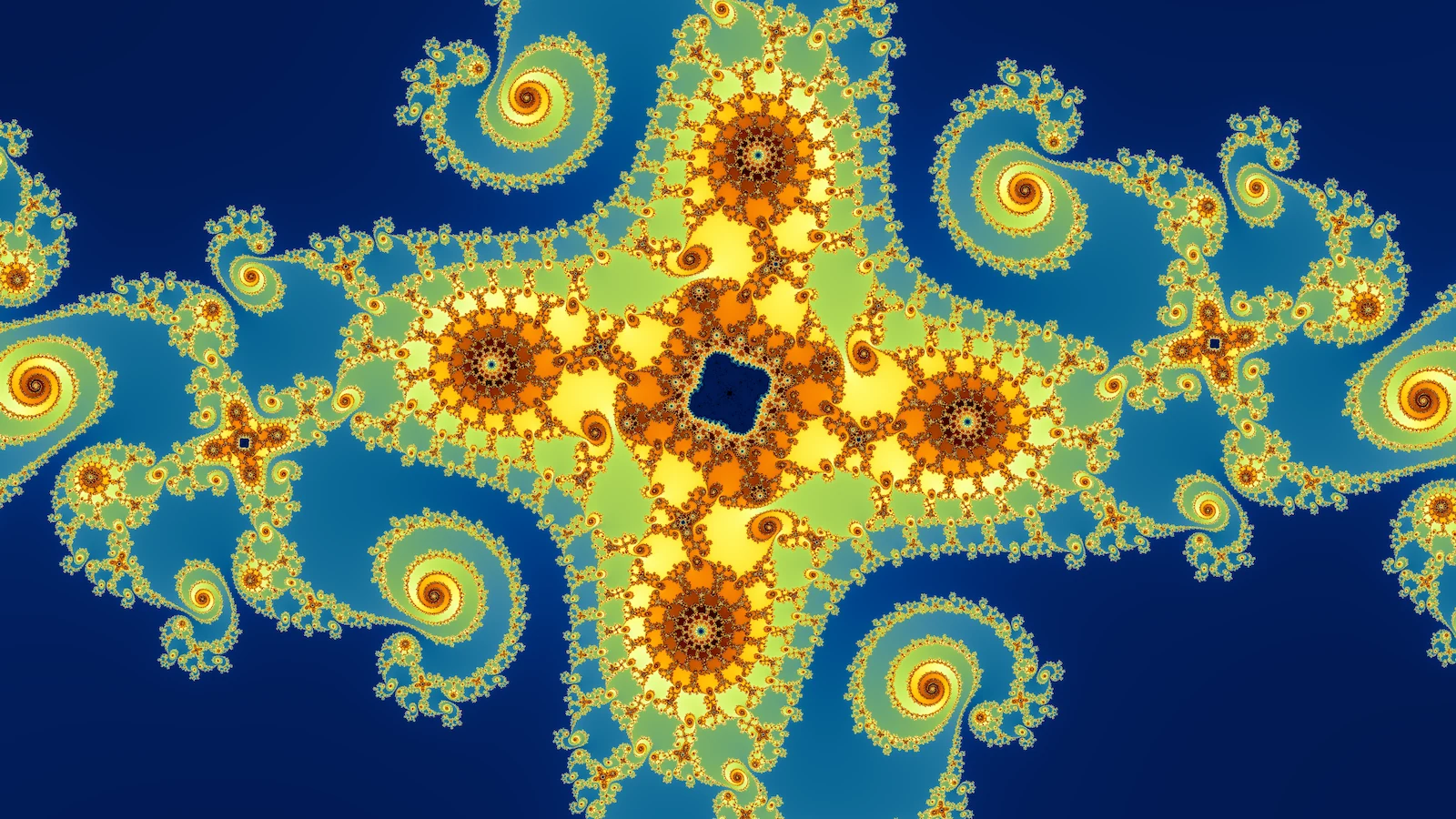 A degree-four Julia set in yellow, orange, and pale green on deep blue: a four-armed cross of filigree around a small dark center, with spirals curling off its edges.